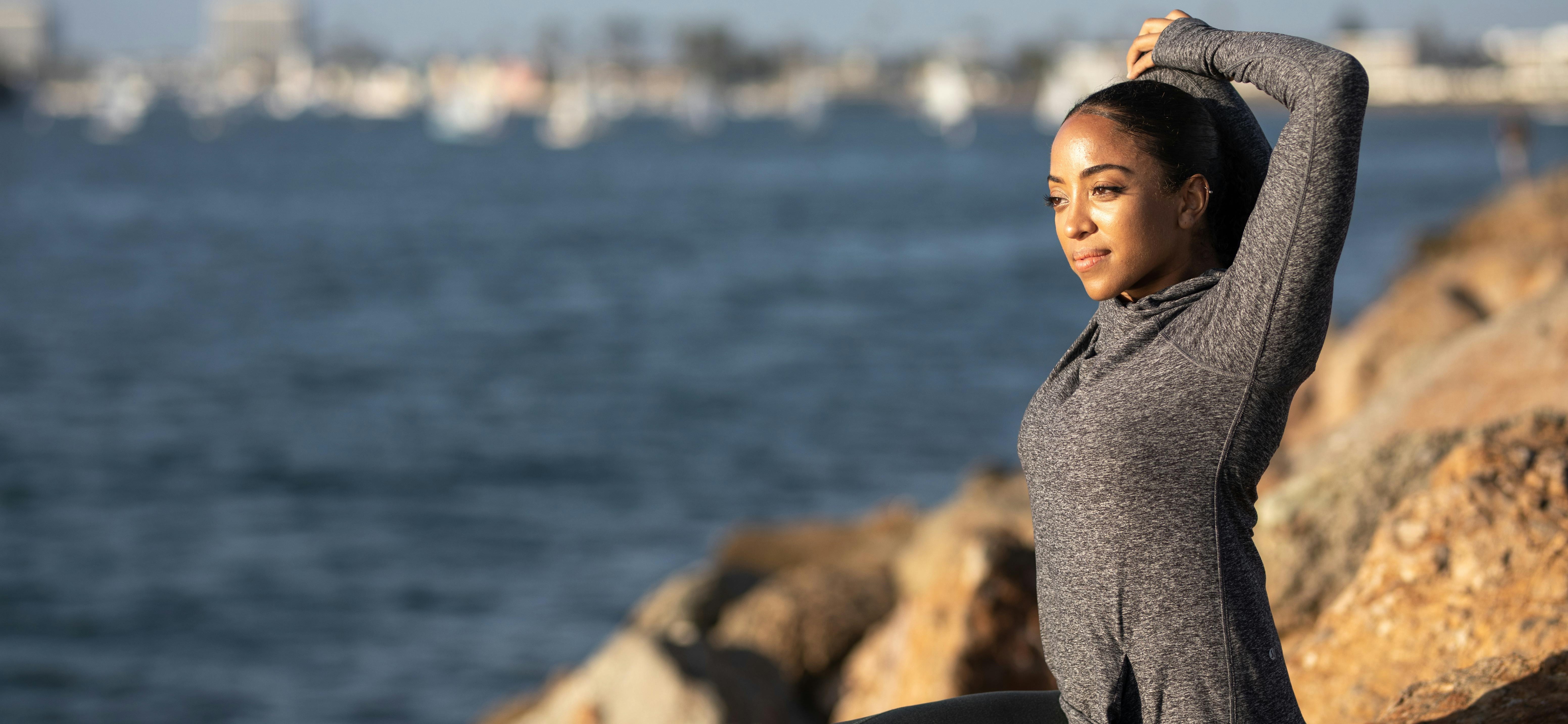 A silhouette of a person watching the sunrise from a hilltop.